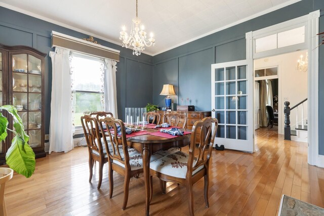 3310 Booker Ridge Rd, Mount Pleasant, TN 38474 - dining space with a chandelier, ornamental molding, a decorative wall, light wood finished floors, and french doors