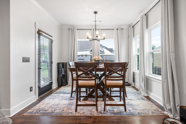 dining area featuring a chandelier, dark wood-type flooring, baseboards, and ornamental molding