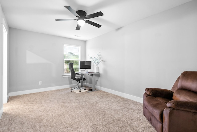carpeted office space with baseboards and a ceiling fan