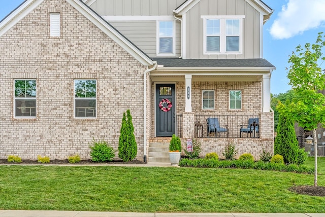 view of front of house featuring board and batten siding, a front yard, and a porch