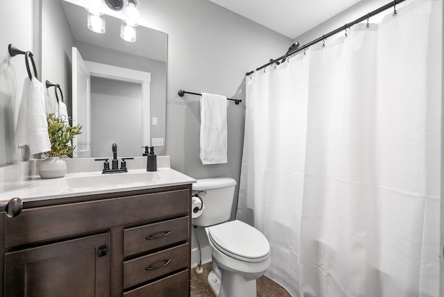 bathroom featuring toilet, vanity, and curtained shower