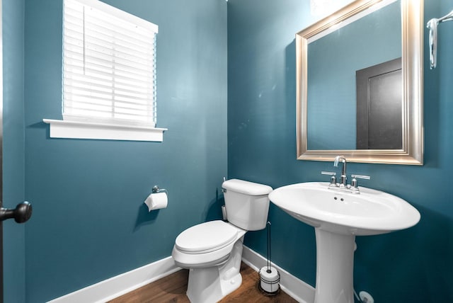bathroom with wood finished floors, baseboards, and toilet
