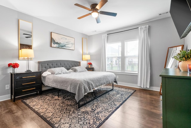 bedroom with dark wood-type flooring, baseboards, and ceiling fan
