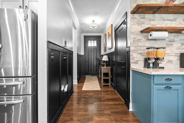 kitchen featuring freestanding refrigerator, ornamental molding, dark wood-style flooring, blue cabinets, and light countertops