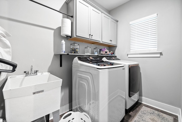 laundry room featuring cabinet space, washing machine and clothes dryer, baseboards, and dark tile patterned flooring