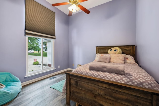 bedroom with wood finished floors, baseboards, and ceiling fan