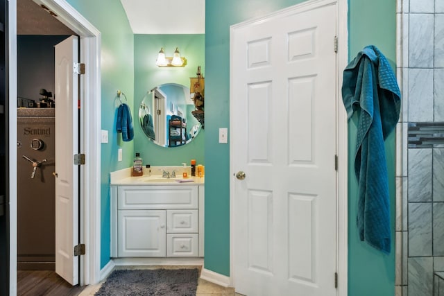 full bathroom with vanity and baseboards