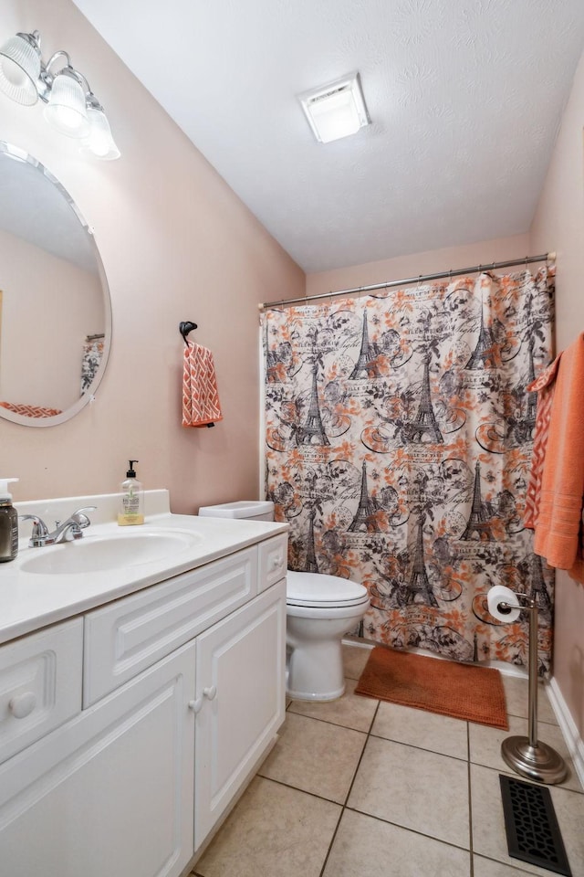 full bath featuring toilet, vanity, and tile patterned flooring