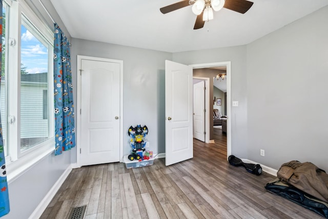 unfurnished bedroom featuring wood finished floors, baseboards, and ceiling fan