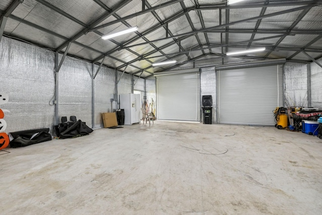 garage with metal wall and white refrigerator with ice dispenser