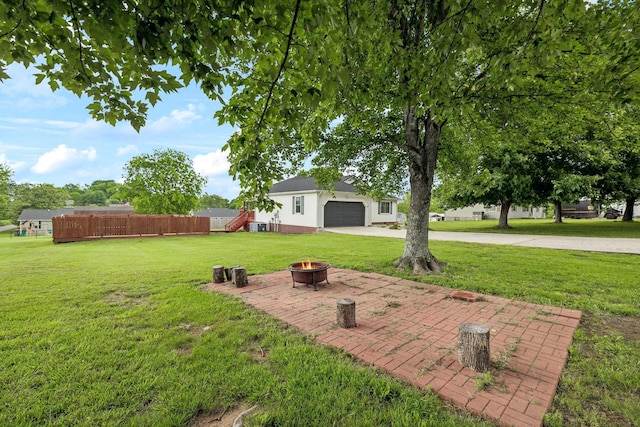 view of yard with a fire pit and driveway