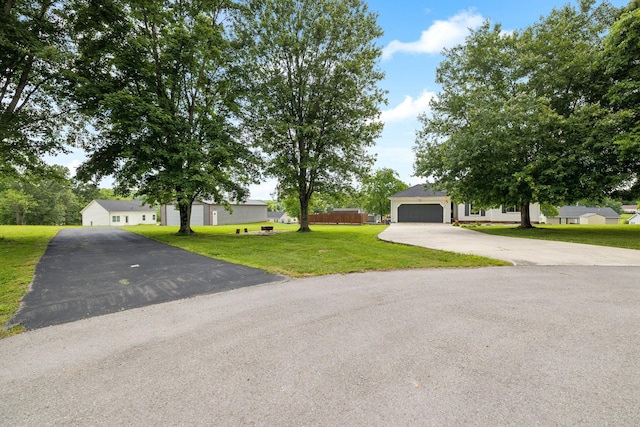 obstructed view of property featuring driveway, a garage, and a front yard