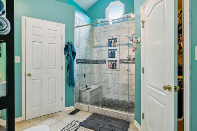 bathroom with a shower stall, baseboards, tile patterned flooring, and a walk in closet