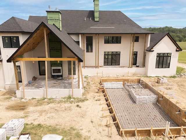 7007 Belcastle Ln, College Grove, TN 37046 - rear view of property with a shingled roof, stucco siding, and a chimney
