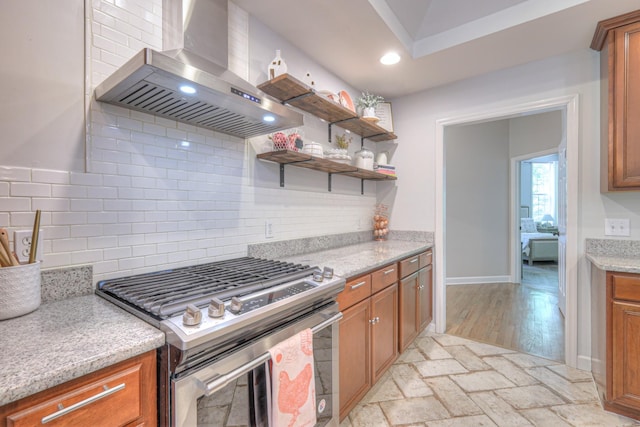 114 Moonlight Dr, Gallatin, TN 37066 - kitchen with stainless steel range with gas stovetop, wall chimney exhaust hood, brown cabinets, decorative backsplash, and recessed lighting