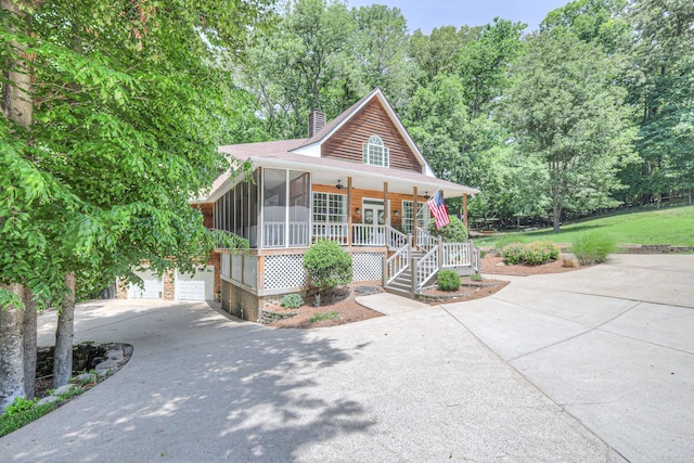 114 Moonlight Dr, Gallatin, TN 37066 - view of front facade with driveway, a chimney, a garage, covered porch, and a sunroom