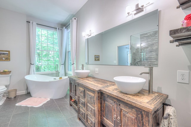 114 Moonlight Dr, Gallatin, TN 37066 - bathroom featuring a freestanding tub, double vanity, toilet, and tile patterned floors