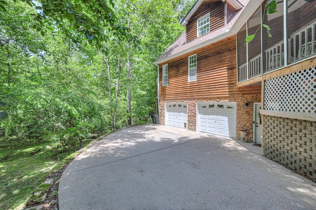 114 Moonlight Dr, Gallatin, TN 37066 - view of side of home featuring stone siding, driveway, and a garage