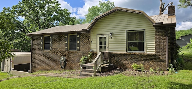 10172 W Oak Dr, Bon Aqua, TN 37025 - view of front of house featuring brick siding, a chimney, a front lawn, and metal roof
