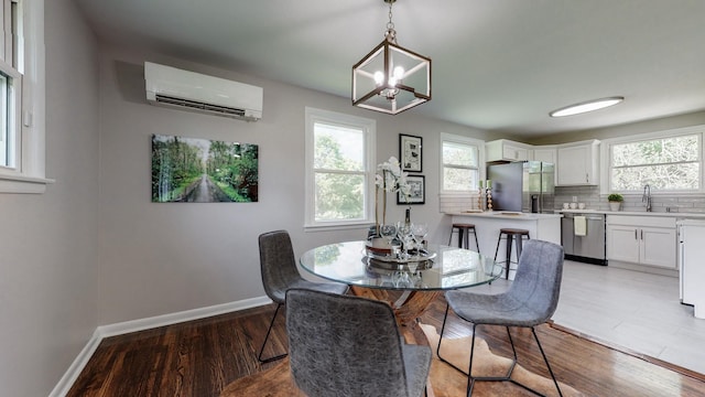 1304 Cheshire Dr, Nashville, TN 37207 - dining room with a wall mounted AC, a chandelier, baseboards, and light wood-type flooring