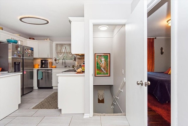 1304 Cheshire Dr, Nashville, TN 37207 - kitchen with stainless steel appliances, light countertops, decorative backsplash, white cabinets, and light tile patterned floors
