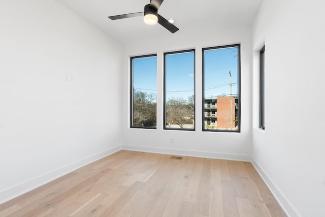empty room with light wood-style flooring, baseboards, and a ceiling fan