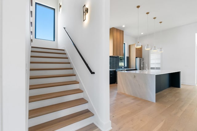 stairs featuring wood finished floors, recessed lighting, and baseboards