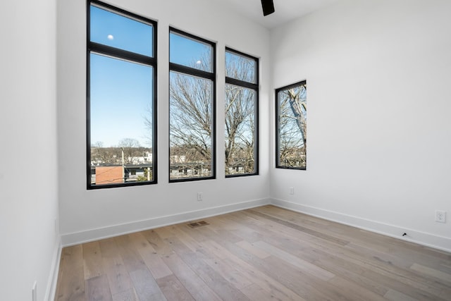 unfurnished room with light wood-style floors, baseboards, and ceiling fan
