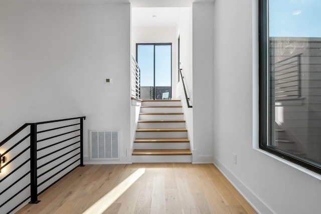 staircase with baseboards and wood finished floors