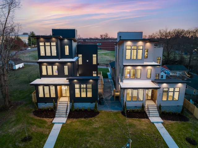 back of property at dusk with stairway, crawl space, and a lawn
