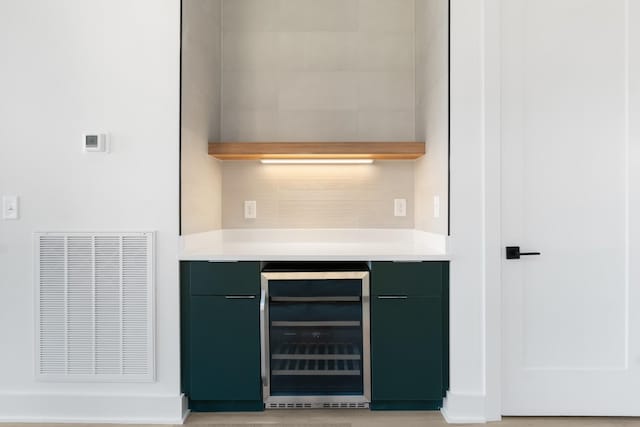 bar featuring beverage cooler and tasteful backsplash