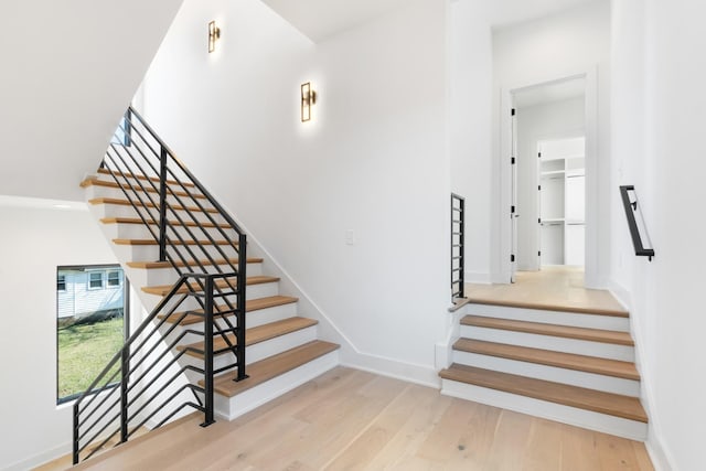 staircase featuring wood finished floors and baseboards