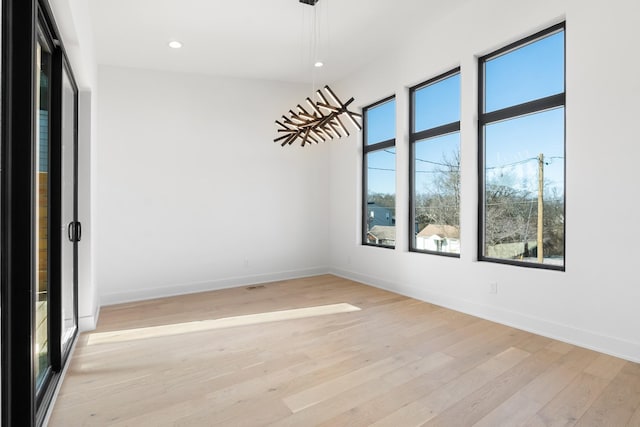 empty room featuring healthy amount of natural light, light wood finished floors, baseboards, and recessed lighting