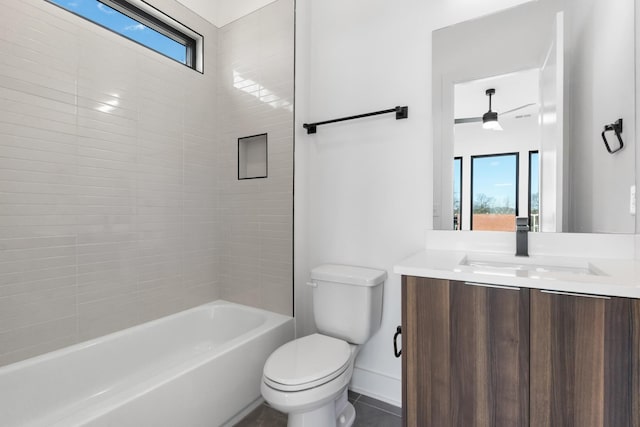 bathroom with toilet, vanity, baseboards, and shower / washtub combination