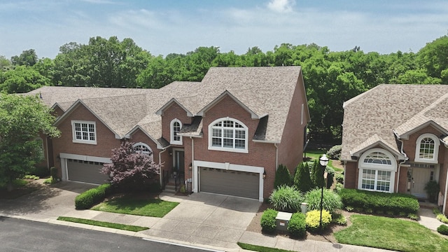 1005 Peck Pl, Hendersonville, TN 37075 - view of front of house with an attached garage, concrete driveway, brick siding, and a shingled roof