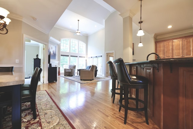1005 Peck Pl, Hendersonville, TN 37075 - kitchen with a ceiling fan, a breakfast bar, ornamental molding, a towering ceiling, and decorative light fixtures