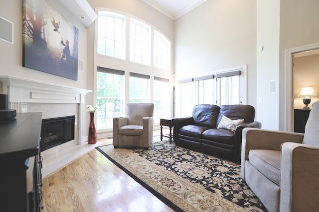 1005 Peck Pl, Hendersonville, TN 37075 - living area featuring ornamental molding, wood finished floors, a high ceiling, and a tiled fireplace