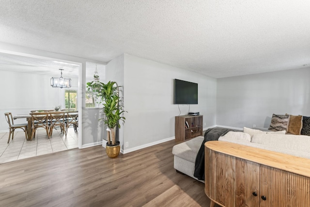 211 Elmwood Dr, Murfreesboro, TN 37128 - living area featuring wood finished floors, a textured ceiling, a chandelier, and baseboards