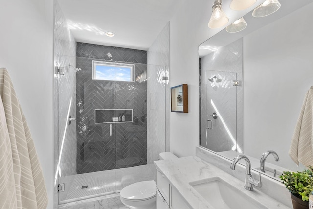 bathroom featuring toilet, a shower stall, vanity, and marble look tiles