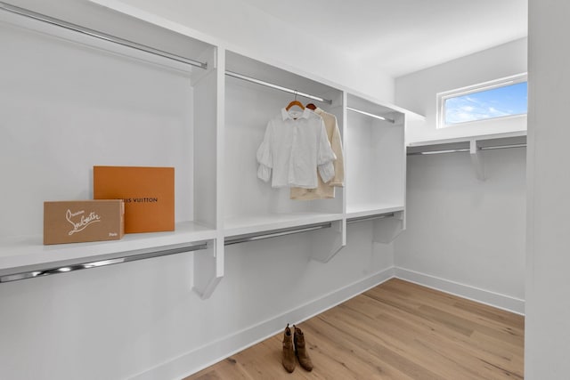 walk in closet with wood finished floors