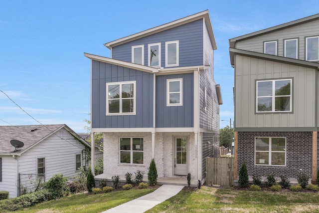contemporary house with board and batten siding, fence, and brick siding
