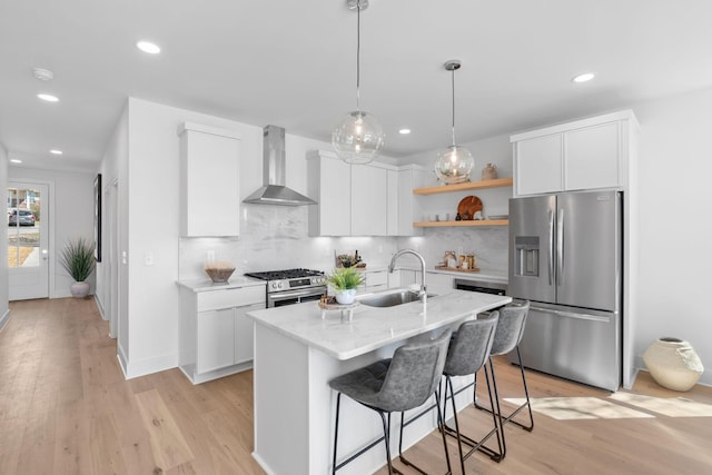 kitchen with stainless steel appliances, wall chimney exhaust hood, a sink, open shelves, and recessed lighting