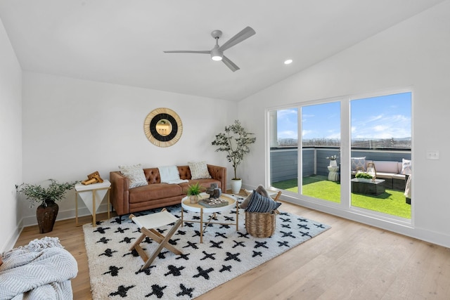 living room featuring vaulted ceiling, wood finished floors, a ceiling fan, baseboards, and a water view
