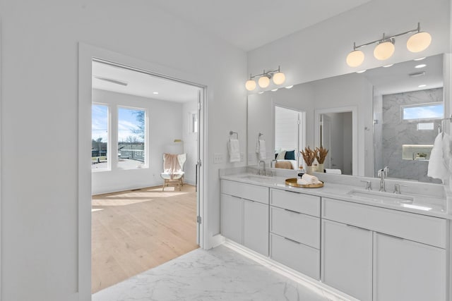 bathroom featuring walk in shower, double vanity, and marble finish floors
