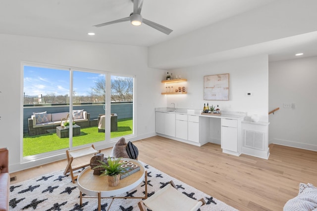 living room with light wood finished floors, recessed lighting, baseboards, ceiling fan, and lofted ceiling