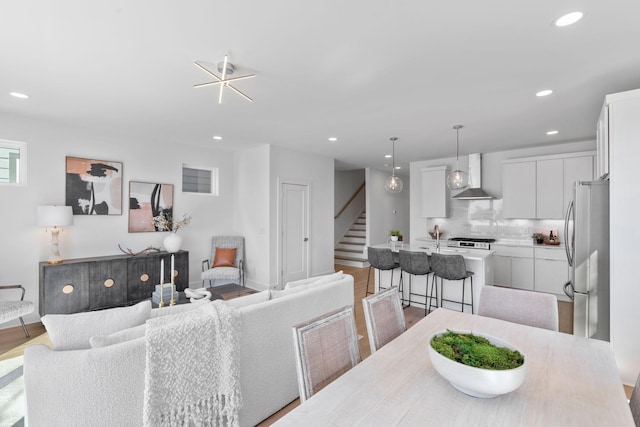 dining area with stairway, recessed lighting, light wood-style flooring, and baseboards