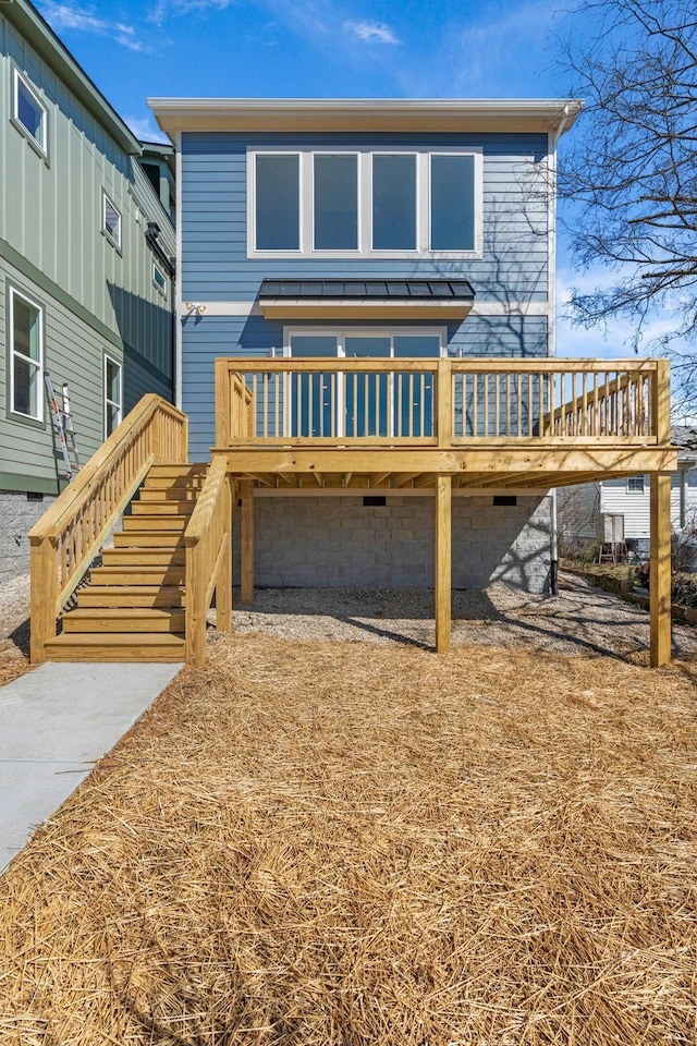 back of house featuring a standing seam roof, a wooden deck, and metal roof