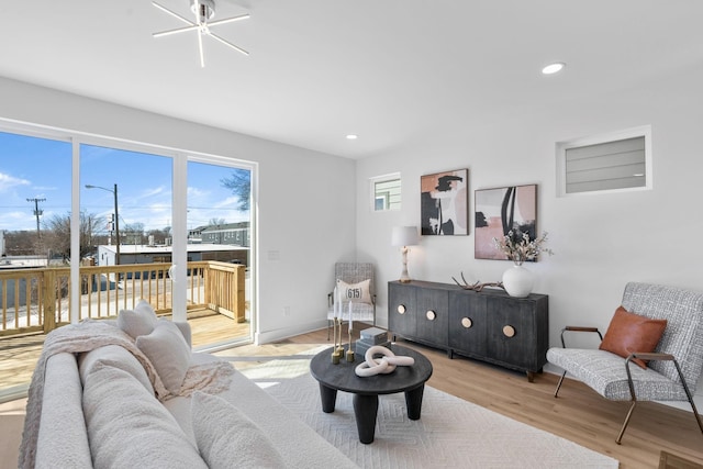 living room with healthy amount of natural light, light wood-type flooring, and recessed lighting