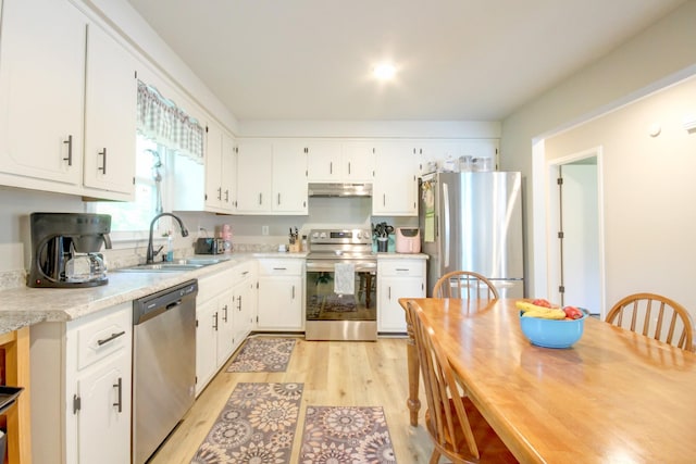2878 Gusty Ln, Clarksville, TN 37043 - kitchen with stainless steel appliances, under cabinet range hood, a sink, light wood finished floors, and light countertops