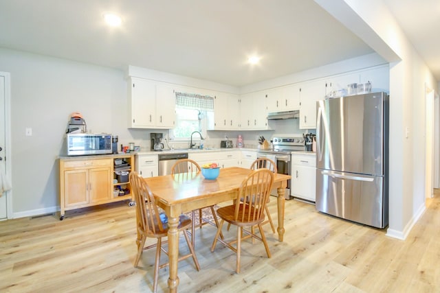 2878 Gusty Ln, Clarksville, TN 37043 - kitchen featuring stainless steel appliances, under cabinet range hood, light wood-style floors, baseboards, and recessed lighting